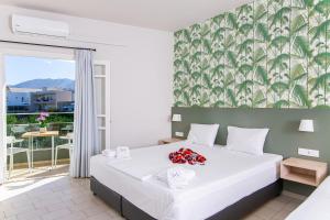 a bedroom with a large white bed with flowers on it at Sunshine Studios in Malia