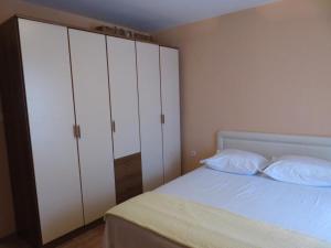 a bedroom with a bed with white cabinets at Saint Stefan Escape in Sveti Stefan