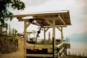 a wooden shelter with a swing at LE TERRAZZE SUL GARDA RELAIS in Biaza