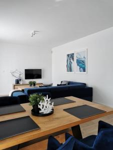 un soggiorno con divano blu e tavolo in legno di Apartamenty PRZYSTAŃ Chłopy a Chłopy