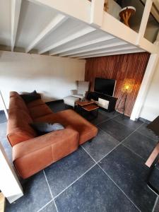 un soggiorno con divano marrone e TV di Guesthouse 66 a Lommel