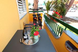 a table with two bottles of wine and a bike on a balcony at Blueciano Rooms in Agrigento +8 photos