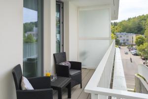 balkon z krzesłami i widokiem na ulicę w obiekcie Apartment Redlowo & 2 bedrooms & Parking by Renters w mieście Gdynia