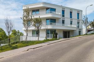 biały budynek przy drodze w obiekcie Apartment Redlowo & 2 bedrooms & Parking by Renters w mieście Gdynia