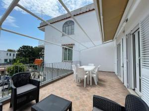 eine Terrasse mit einem Tisch und Stühlen auf dem Balkon in der Unterkunft Casa in centro Ischia Porto Forever Four in Ischia