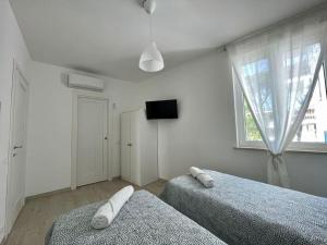 1 Schlafzimmer mit 2 Betten und einem Flachbild-TV in der Unterkunft Casa in centro Ischia Porto Forever Four in Ischia