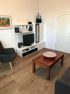 ein Wohnzimmer mit einem Couchtisch und einem TV in der Unterkunft Möbiliertes wohnen auf dem Sandberg in Flensburg