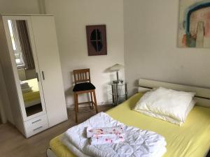 ein Schlafzimmer mit einem Bett mit zwei Kissen und einem Spiegel in der Unterkunft Möbiliertes wohnen auf dem Sandberg in Flensburg