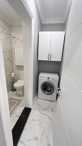 a white bathroom with a washing machine and a toilet at KELES HOME in Trabzon