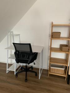 an office desk with a chair and a book shelf at Beautiful modern country home in Wegberg