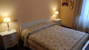 a bedroom with a bed and two night stands with lamps at Casa Daniela in Bagni di Lucca