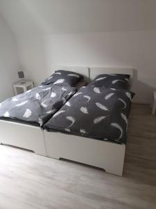 a bed with black and white sheets and pillows at Ferienwohnung Herzberg in Loxstedt