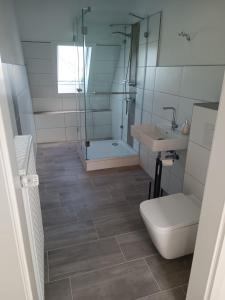 a bathroom with a shower and a toilet and a sink at Ferienwohnung Herzberg in Loxstedt