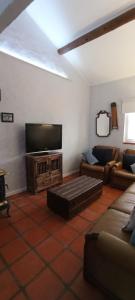 sala de estar con sofá y TV de pantalla plana en Cantinho, Alojamento Local, en Luso