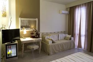 a living room with a couch and a table and a tv at Hotel Tirreno in Trapani