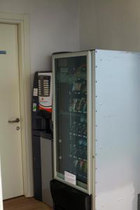 Un refrigerador en una habitación al lado de un microondas. en LE TERRAZZE SUL GARDA RELAIS, en Biaza