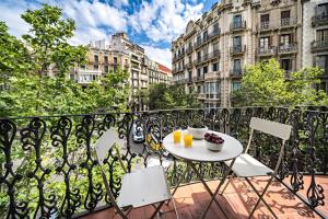 einen Tisch und Stühle auf einem Balkon mit Gebäuden in der Unterkunft Habitat Apartments Barcelona Balconies in Barcelona