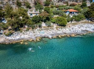 an aerial view of a beach with people in the water at Petra Mare Apartments in Alyki