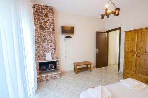 a living room with a fireplace and a wooden door at Petra Mare Apartments in Alyki