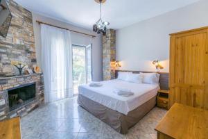 1 dormitorio con 1 cama grande y chimenea en Petra Mare Apartments, en Alyki
