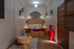 a bedroom with a bed and a red vase at Riad Le Plein Sud in Marrakech