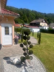 un pequeño árbol en un patio al lado de una casa en Toscana-Residenz im Schwarzwald, en Utzenfeld