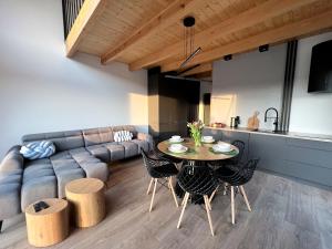 uma sala de estar com um sofá, uma mesa e cadeiras em Domki Grabina 