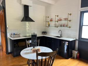 a kitchen with a table and a sink and a stove at Murray River Spa Retreat in Echuca