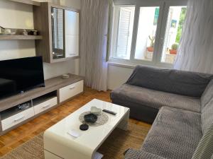 a living room with a couch and a tv at House Bartulović in Brela