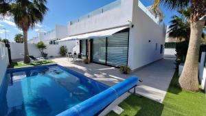 a swimming pool in front of a house at Holidoo Travel "Villa Deluxe" in Los Alcázares