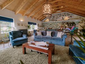 a living room with blue couches and a table at Balsoon Lodge in Navan