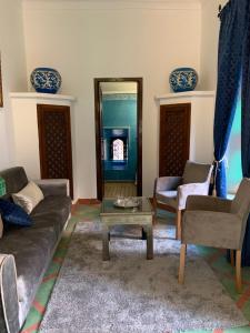 ein Wohnzimmer mit einem Sofa und einem Tisch in der Unterkunft Riad Malida Marrakech in Marrakesch