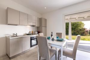 a kitchen and dining room with a white table and chairs at Baia del Sole in Olbia