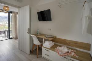 a room with a desk and a tv on the wall at Hermagio Villa Hermione by Estia in Malia