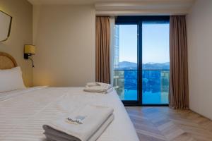 a hotel room with two beds and a large window at MiraMar Luxury Residences in Batumi