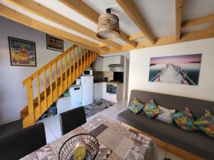 salon z kanapą i stołem w obiekcie Narbonne-Plage - Pavillon à 300 m de la plage w mieście Narbona