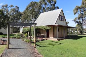 a house with a pergola in front of a yard at Murray River Spa Retreat in Echuca