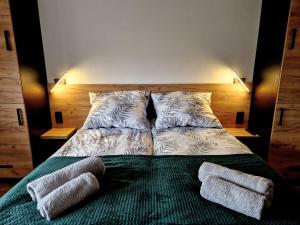 uma cama com duas almofadas e duas toalhas em Bulwary Mszańskie - Pokoje em Mszana Dolna