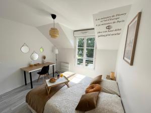 a bedroom with a bed and a desk and a table at COSY TORCY entre Paris et Disney in Torcy