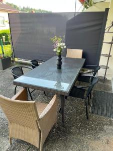 uma mesa com cadeiras e um vaso com flores em Reiheneckhaus mit Garten und Terasse em Tettnang