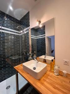 La salle de bains est pourvue d'un lavabo blanc et d'une douche. dans l'établissement Le panier de Clarisse, à Marseille