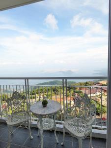 d'une table et de chaises sur un balcon avec vue. dans l'établissement Breezy Tagaytay Condo, à Tagaytay