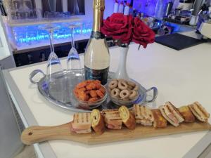 una tabla de cortar con sándwiches y una botella de vino en Hotel Birillo, en La Spezia