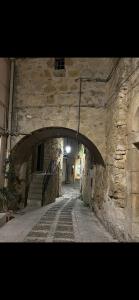 an alley with an archway in a stone building at Salemi BnB in Salemi