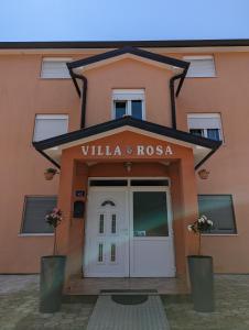 un panneau indiquant la villa androsa devant un bâtiment dans l'établissement Villa Rosa, à Umag