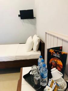Cette chambre comprend un lit et une table avec des bouteilles d'eau. dans l'établissement Morning Star Resorts, à Negombo