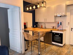 a kitchen with a wooden table and some chairs at Le panier de Clarisse in Marseille