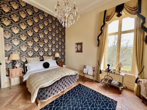 a bedroom with a large bed and a chandelier at Chateau les Villettes in Saint-Just-le-Martel