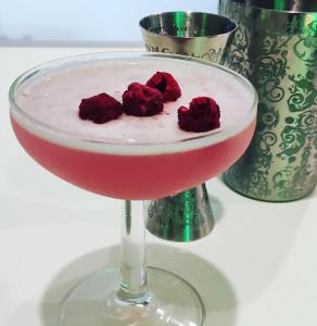 een rode drank in een martini glas met frambozen bij Hotel Birillo in La Spezia