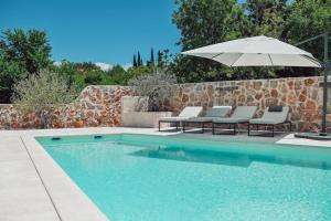 a swimming pool with an umbrella and chairs and a table and an umbrella at Luxury Villa Solea in Barušić +16 photos